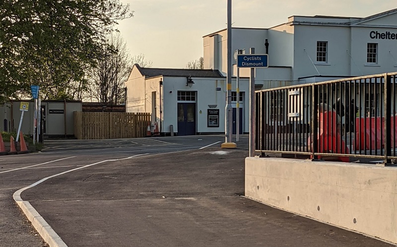 An image towards Cheltenham Spa station showing a cyclists dismount sign