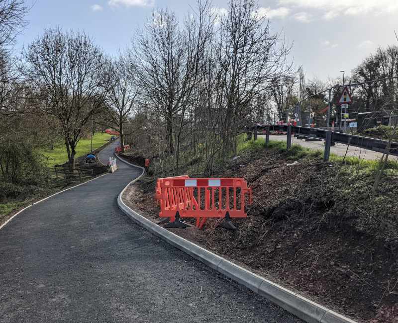 A near complete cycle path passes through woodland in a dip adjacent to the A40 roadworks