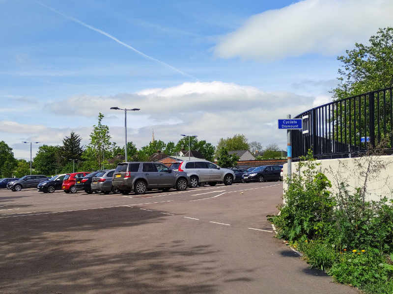 Taken from the car park, a cyclists dismount sign at the bottom of the slop approaching the station forecourt where the campaign has proposed a cycling link alternative.