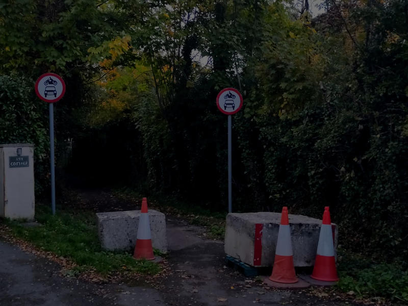 Concrete blocks obscure the entrance to the Pheasant Lane cycle route as darkness falls. The National Highway M5 overbridge closure at Bamfurlong Lane will require cyclists and pedestrians to use this route on a long diversion.