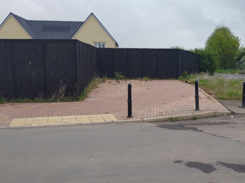 A cycle lane abruptly stops at a boarding where the Gotherington Cycle Lane has yet to be delivered.